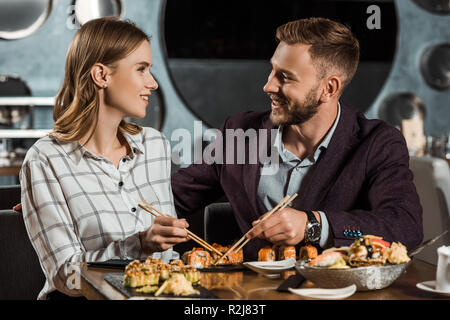 Beau couple heureux amorously regardaient tout en dînant au restaurant Banque D'Images