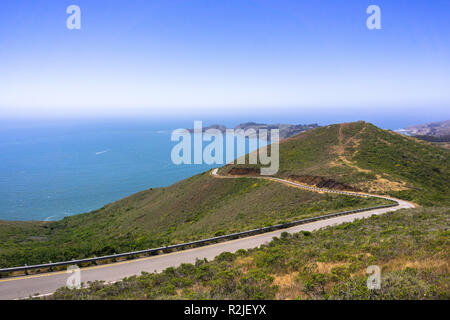 Vue magnifique sur les vertes collines de Marin Headlands traversé par une route sinueuse ; le littoral de l'océan Pacifique à l'arrière-plan ; San Francisco bay Banque D'Images