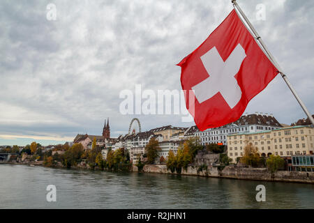 Drapeau suisse sur le Rhin à Bâle, avec le Munster et grande roue à l'arrière-plan Banque D'Images