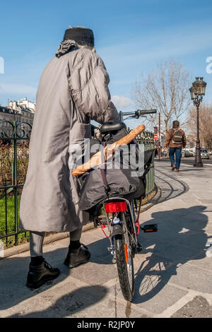 Femme avec location et baguette française typique dans les rues du centre de Paris, France Banque D'Images