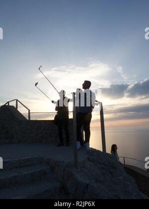 Trois hommes utilisent des bâtons selfies en vacances Banque D'Images