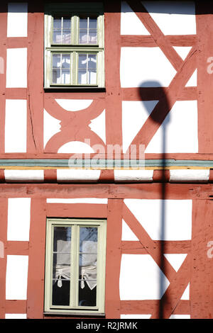 Un réverbère jette une ombre sur la façade lumineuse du faisceau et la construction d'une maison à pans de bois, Banque D'Images