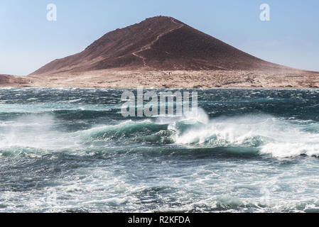 Le volcan Montana Roja sur Tenerife avec la tempête-fouetté baie d'El Medano, à l'avant-plan. Banque D'Images