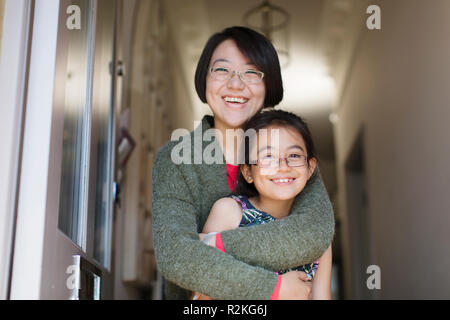 Portrait heureux, affectueux mother and daughter hugging in doorway Banque D'Images