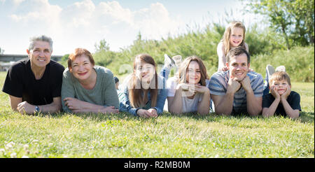 Heureux les gens d'âges différents à prendre des photos sur la pelouse Banque D'Images
