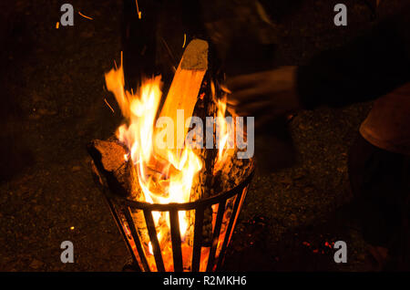 Cheminée en fer avec des bûches au cours d'une soirée froide pour la chaleur. On met sur un autre journal. Banque D'Images