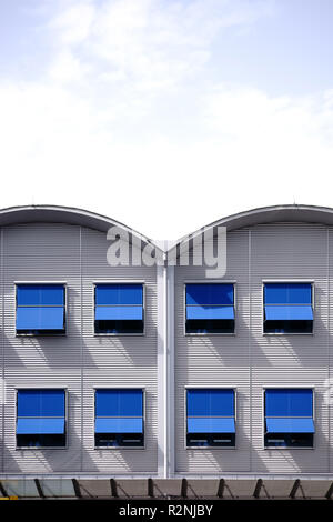 Tôle ondulée moderne façade d'un bâtiment résidentiel avec des rangées de fenêtres et stores aux fenêtres, Banque D'Images