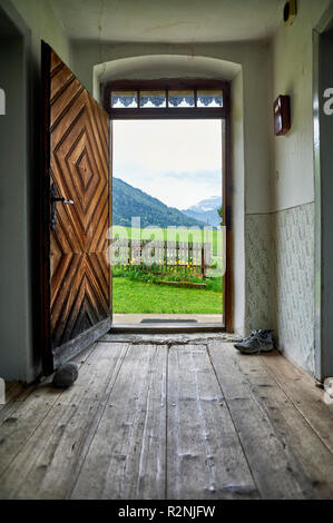 Vue depuis le couloir d'une maison de ferme sur terrain clos Chalet jardin, paysage de montagne derrière Banque D'Images