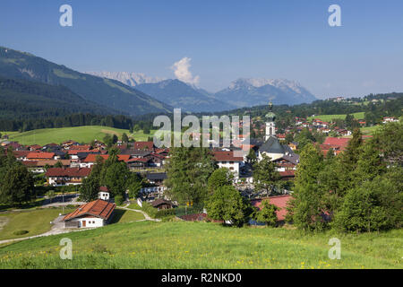 Avis de Reit im Winkl avec l'église paroissiale de Sankt Pankratius derrière elle les Wilder et Montagnes Zahmer Kaiser, Alpes de Chiemgau, Chiemgau, Haute-Bavière, Bavière, Allemagne du sud, l'Allemagne, de l'Europe Banque D'Images