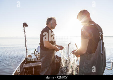 Les pêcheurs Thomas et Florian Lex de la Fraueninsel attraper les filets, Frauenchiemsee, Chiemsee, Chiemgau, Haute-Bavière, Bavière, Allemagne du sud, l'Allemagne, de l'Europe Banque D'Images