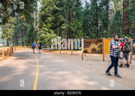 Juillet 17, 2018 La vallée Yosemite / CA / USA - Touristes marcher à travers la vallée et de consultation les panneaux offrant de l'information, Yosemite National Park Banque D'Images