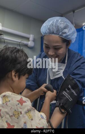 PAITA, Pérou (nov. 1, 2018) - Hospitalman Celeste Soriano, de Houston, joue avec un patient dans une salle d'opération à bord du navire-hôpital USNS Comfort (T-AH 20). Le confort est de 11 semaines sur une mission d'appui médical à l'Amérique centrale et du Sud dans le cadre du U.S. Southern Command's Enduring promesse initiative. Travailler avec des partenaires gouvernementaux et de santé en Équateur, au Pérou, en Colombie et au Honduras, l'équipe médicale a entrepris des soins à bord et dans les sites médicaux, aide à relâcher la pression sur les systèmes médicaux causée en partie par une augmentation des migrants transfrontaliers. L'deploymen Banque D'Images