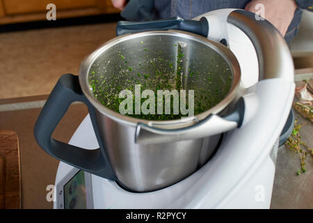 Séries de photos, étape par étape, la préparation d'un gigot d'agneau farci aux herbes et légumes provençaux en utilisant un processeur de nourriture (Thermomix ® et Varoma ®), la préparation de la garniture d'herbes Banque D'Images