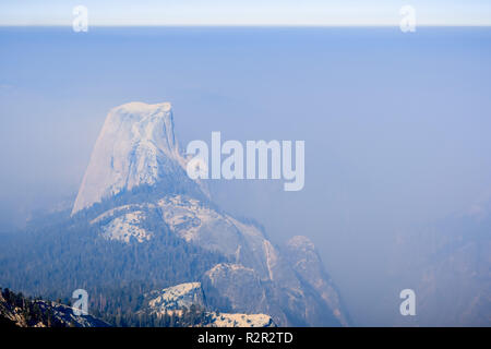 Vue vers Demi Dôme et la vallée au-delà d'une journée avec une visibilité réduite en raison de la fumée venant de la Ferguson Fire, Yosemite National Park Banque D'Images