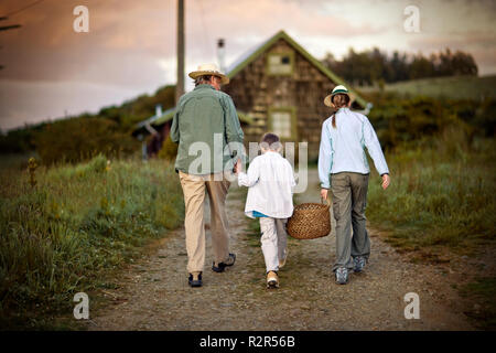 Adulte mature man walking up un chemin avec sa petite-fille et les jeunes petit-fils. Banque D'Images