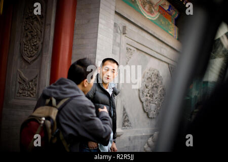 Teenage boy standing avec un ami à l'extérieur de l'école. Banque D'Images