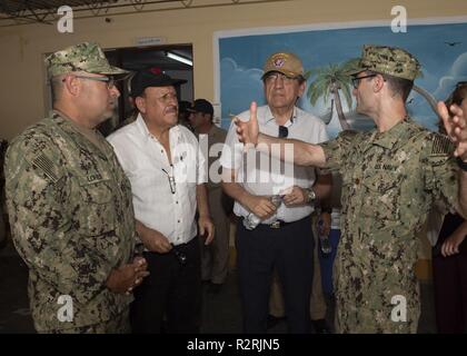 PAITA, Pérou (nov. 03, 2018) Le lieutenant Cmdr. Peter MCINTYRE (à droite), l'officier en charge d'un site médical, explique les services médicaux fournis à Jorge Castillo (centre-droit), Président de la défense du Pérou, et Sergio Davila, un représentant de l'avocat de la défense du Pérou, tandis que le lieutenant Cmdr. Gustavo traduit Lores. Le navire-hôpital USNS Comfort (T-AH 20) est de 11 semaines sur une mission d'appui médical à l'Amérique centrale et du Sud dans le cadre du U.S. Southern Command's Enduring promesse initiative. Travailler avec des partenaires gouvernementaux et de santé en Équateur, au Pérou, en Colombie et au Honduras, l'équipe médicale a entrepris Banque D'Images