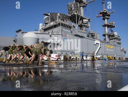 Le Golfe Arabique (nov. 5, 2018) marins affectés à la classe Wasp-navire d'assaut amphibie USS Essex (DG 2) et les Marines affectés à 13e Marine Expeditionary Unit (MEU) participer à un vol Brosse lave-pont au cours d'un déploiement prévu de la Essex Groupe amphibie (ARG) et 13e MEU. L'Essex ARG/13e MEU est un programme souple et persistante Navy-Marine Corps équipe déployée à la 5e flotte américaine Secteur d'opérations à l'appui des opérations navales pour assurer la stabilité et la sécurité maritime dans la région Centrale, reliant la Méditerranée et le Pacifique à travers l'ouest de l'Océan indien et trois strat Banque D'Images