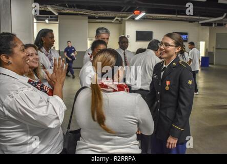 Michigan Army National Guard Soldat SPC. Samantha Hall et l'unité de l'équipe Arsenal Detroit Ministère Choeur célèbre après avoir chanté l'hymne national à l'Detroit Pistons 'Hoops' pour les troupes contre le Miami Heat jeu 5 novembre à l'Arène Little Caesars à Detroit, Michigan. Les membres de la chorale espérance à chanter à l'avenir des événements sportifs à l'aréna. Banque D'Images