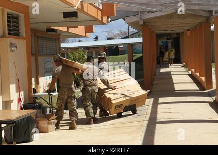 SAIPAN, Commonwealth des îles Mariannes du Nord - Trois soldats de l'Armée avec la 368e Compagnie de Police Militaire, 9ème commande de soutien de mission, aider à transporter environ 250 Croix Rouge américaine lits bébés à l'Tanapag Middle School à Saipan, Commonwealth des îles Mariannes du Nord, le 7 novembre. Les membres en service de région mixte Marianas et à d'autres unités de l'intérieur de la commande de l'Indo-Pacifique assigné à la Force-West fournissent à l'appui du Département de la Défense civile de la CNMI et de fonctionnaires locaux dans le cadre de la prise en charge de la FEMA Typhoon Yutu les efforts de rétablissement. Banque D'Images