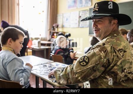 SFC. John Bryant du 278e à l'Ukraine a déployé d'ACR est assis avec les enfants à l'École de centre de réadaptation pour les enfants ayant des besoins spéciaux, le 7 novembre. Banque D'Images