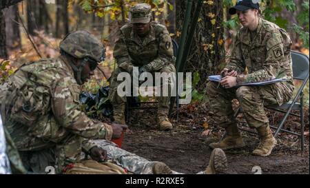 Un soldat en compétition pour l'expert médical sur le terrain d'un insigne effectue des soins aux blessés, tout en étant évalués par un instructeur le 6 novembre 2018 à Fort Bragg, NC. L'EFMB a été créé pour faire connaître et reconnaître les soldats pour leur niveau de compétence et la compétence dans le domaine médical. Le test se compose d'un examen écrit, la navigation terrestre, trois voies d'essai de combat et se termine par un 12-mile ruck mars. Banque D'Images