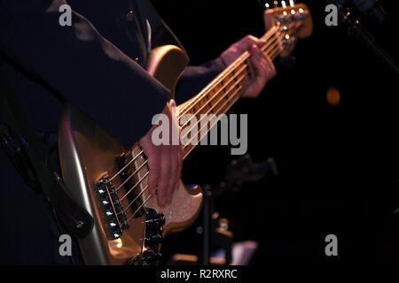 Tech. Le Sgt. Michael Schmaus, U.S. Air Force Heartland of America Band bassiste et directeur musical, strum sa basse pendant la Journée des anciens combattants un concert à l'Auditorium Chester Fritz 6 Novembre, 2018, à Grand Forks, Dakota du Nord. L'Heartland of America Band est constitué de 15 membres qui présente la musique édifiante et passionnante d'inspirer le patriotisme et faire connaître la Force aérienne. Banque D'Images