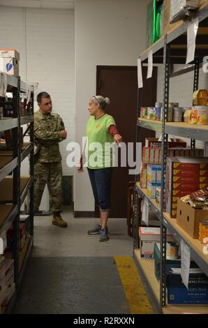 FORT BENNING, en Géorgie (nov. 8, 2018) - Le Lieutenant-colonel Nathan Palisca, à gauche), commandant du 3e Bataillon du 81e régiment blindé, reçoit une visite de la bataille Buddy Resource Centre à partir de la co-directeur Amy Mason. Le 3e Bataillon, 81e régiment blindé, a tenu une collecte de denrées pour la bataille Buddy Resource Center à Fort Benning, Géorgie, la livraison de marchandises non périssables au centre le 8 novembre 2018. Banque D'Images
