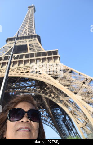 Senior citizen poser pour des photos avec la Tour Eiffel en arrière-plan, Paris, France Banque D'Images