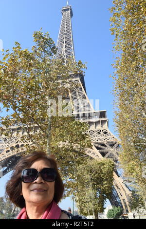 Senior citizen poser pour des photos avec la Tour Eiffel en arrière-plan, Paris, France Banque D'Images