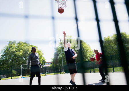 Senior hommes jouant au basket-ball à sunny park Banque D'Images