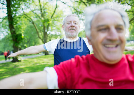 Senior hommes exerçant, stretching en park Banque D'Images