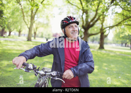 Senior man riding bike in park Banque D'Images