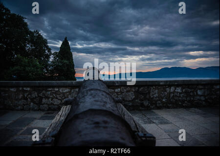 Vieux canon en fonte avec vue sur mer à partir de mur de château avec le coucher du soleil et des couleurs intenses, Trsat Croatie. Banque D'Images