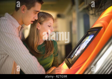 Jeune couple jouant un jeu d'arcade. Banque D'Images