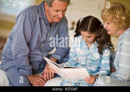 Les grands-parents avec sa petite-fille en pyjama portrait Banque D'Images