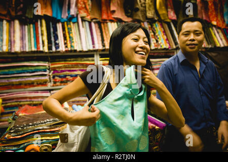 Jeune femme d'une robe de style traditionnel à l'intérieur d'un magasin de tissu. Banque D'Images