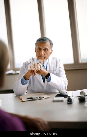 Friendly senior doctor converser avec un patient. Banque D'Images