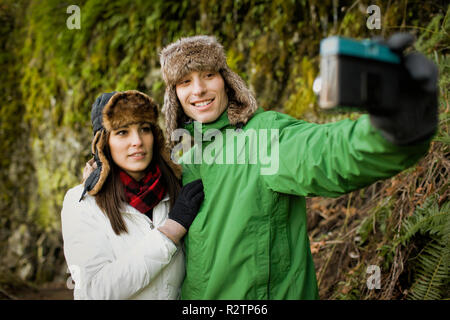 Jeune couple portant des chapeaux de fourrure de prendre une photo d'eux-mêmes. Banque D'Images