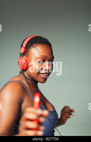 Jeune femme sans souci avec un casque et un lecteur mp3 dancing Banque D'Images
