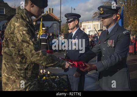Le Lieutenant-colonel de l'US Air Force Ryan White, 100e groupe de maintenance sous-commandant de groupe et de la Royal Air Force Sqd. Ldr. Paul Graham, RAF Mildenhall commandant de station passer une couronne de pavot à être mis sur le monument commémoratif de guerre du Canada au cours du Jour du Souvenir à Mildenhall, Angleterre, le 11 novembre, 2018. White et Graham présente la ville avec une couronne de fleurs de pavot en souvenir de la Première Guerre mondiale, au nom de l'équipe de Mildenhall aviateurs et membres du personnel civil. Banque D'Images
