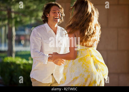 Smiling couple danse ludique sur un patio. Banque D'Images