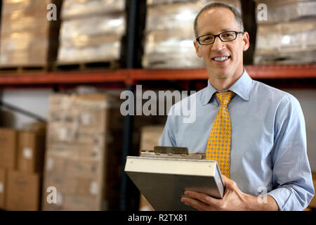 Portrait of a smiling businessman taking notes sur un presse-papiers. Banque D'Images