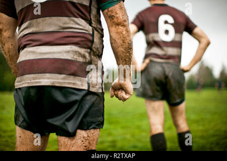 Vue arrière de deux joueurs de rugby boueux sur le terrain. Banque D'Images