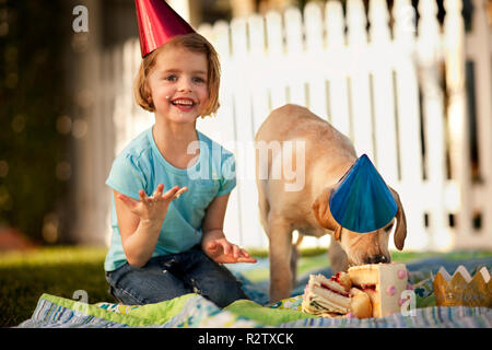 Jeune fille ayant un pique-nique avec son chiot. Banque D'Images