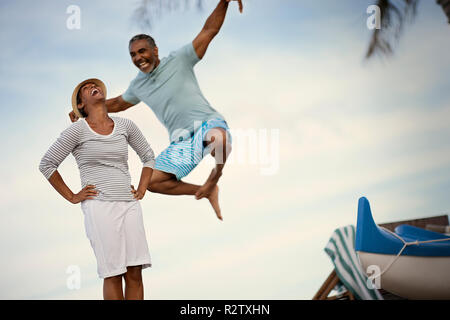 D'âge mûr pour rire, sauter et faire des mouvements de karaté sur la plage. Banque D'Images