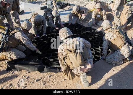 Les Marines américains avec l'Escadron de soutien de l'aile Marine 274 déposer une couche de sable sable tout en menant une simulation de la réparation des dommages de l'aérodrome de l'évaluation environnementale au cours de l'exercice de formation intégrée (ITX) le Marine Corps Air Ground Combat Center Twentynine Palms, California, 8 novembre 2018. L'ITX est une grande échelle, exercice d'entraînement interarmes destiné à produire des forces prêtes au combat capable de fonctionner comme un système intégré de Marine air-sol task force. Banque D'Images