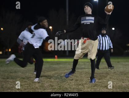 Le s.. Jacob Stankiewicz, Stankiewicz SF quarterback, jette tout en étant poursuivi par un membre de la 1re classe Joshua Robertson, SF Sykes poseur, au cours de l'intra-muros 2018 flag football championnat à Kirtland Air Force Base, N.M., 8 novembre. Banque D'Images