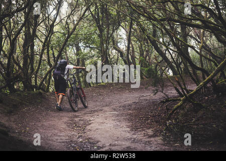 Guides de montagne le vélo en forêt tropicale. Banque D'Images