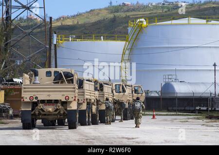 La Garde nationale armée Guam affecté à la 1224e Compagnie de soutien ingénieur à pied vers leur lumière véhicules tactiques moyen attribué à la 9ème commande de soutien de mission, Réserve de l'armée, Honolulu, en front de mer après le déchargement des véhicules sur Saipan, Commonwealth des îles Mariannes du Nord, Novembre 12, 2018, dans le cadre de la super typhon Yutu de secours. Plus de 800 lieux d'active, de réserve et garde côtière canadienne les membres en service de plus de 20 unités différentes dans toutes les directions générales de services au sein de la commande de l'Indo-Pacifique américain appuient la Federal Emergency Management conduire les efforts de rétablissement, qui a commencé Banque D'Images